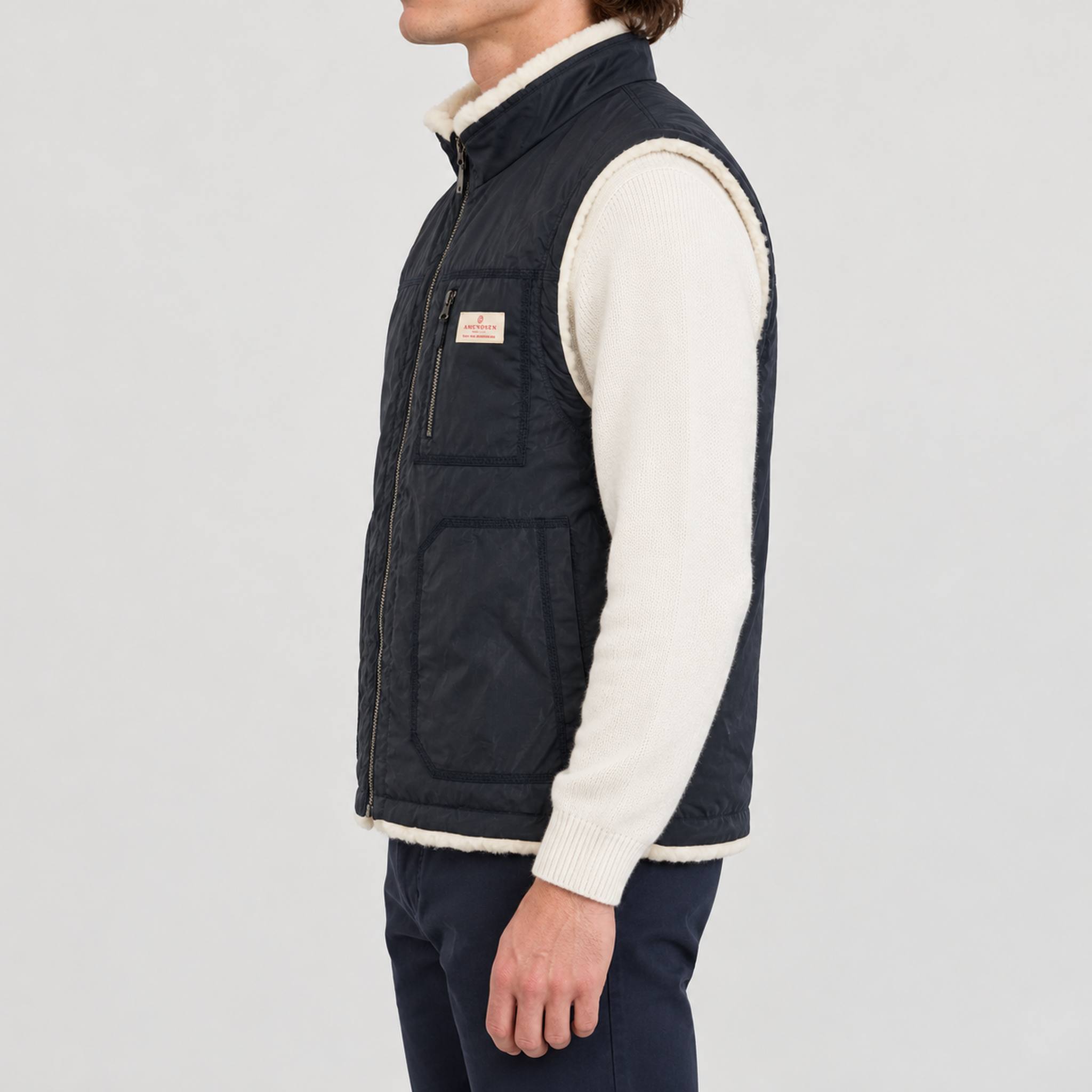 Amundsen Harvester Reverso Waxed Vest, side view on model, navy waxed side.