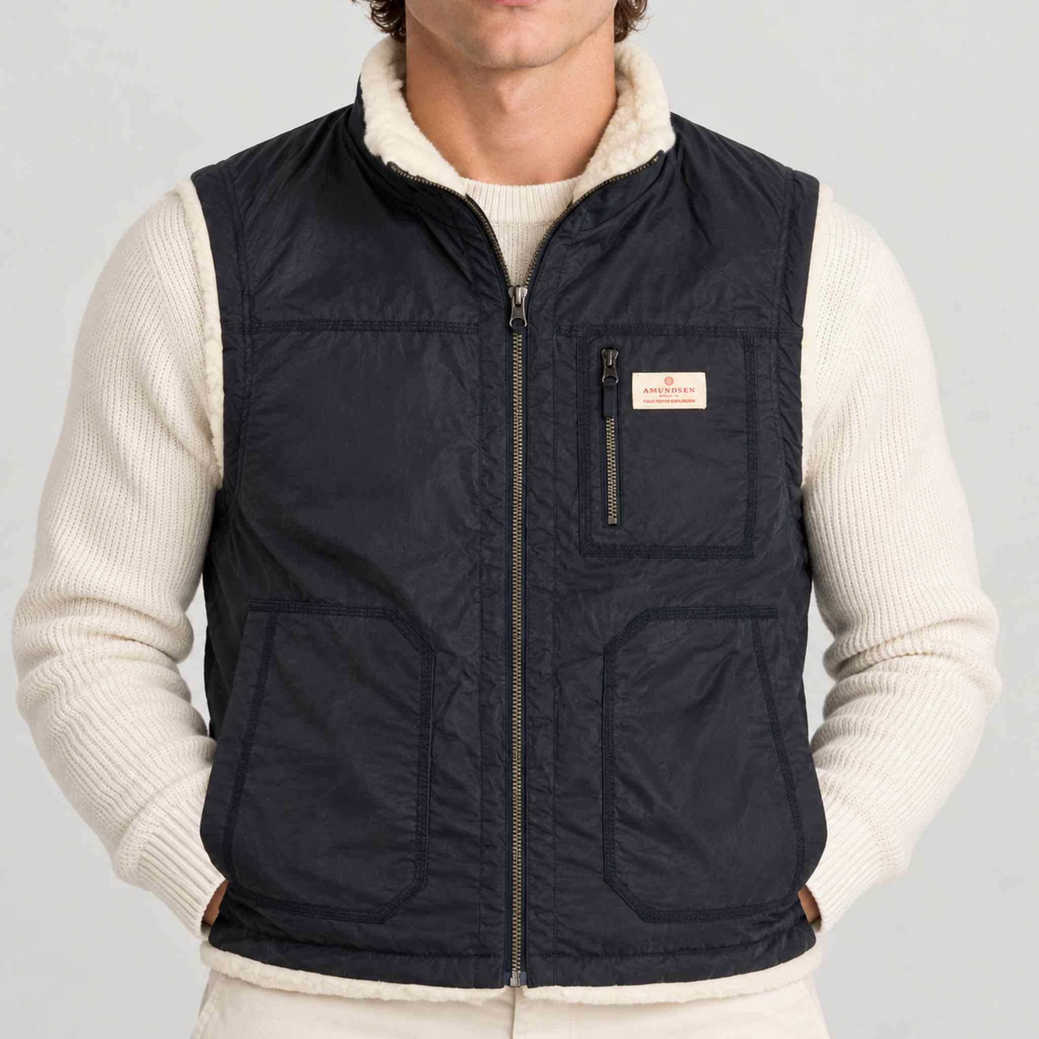 Amundsen Harvester Reverso Waxed Vest, close-up fabric detail on model, navy waxed side.