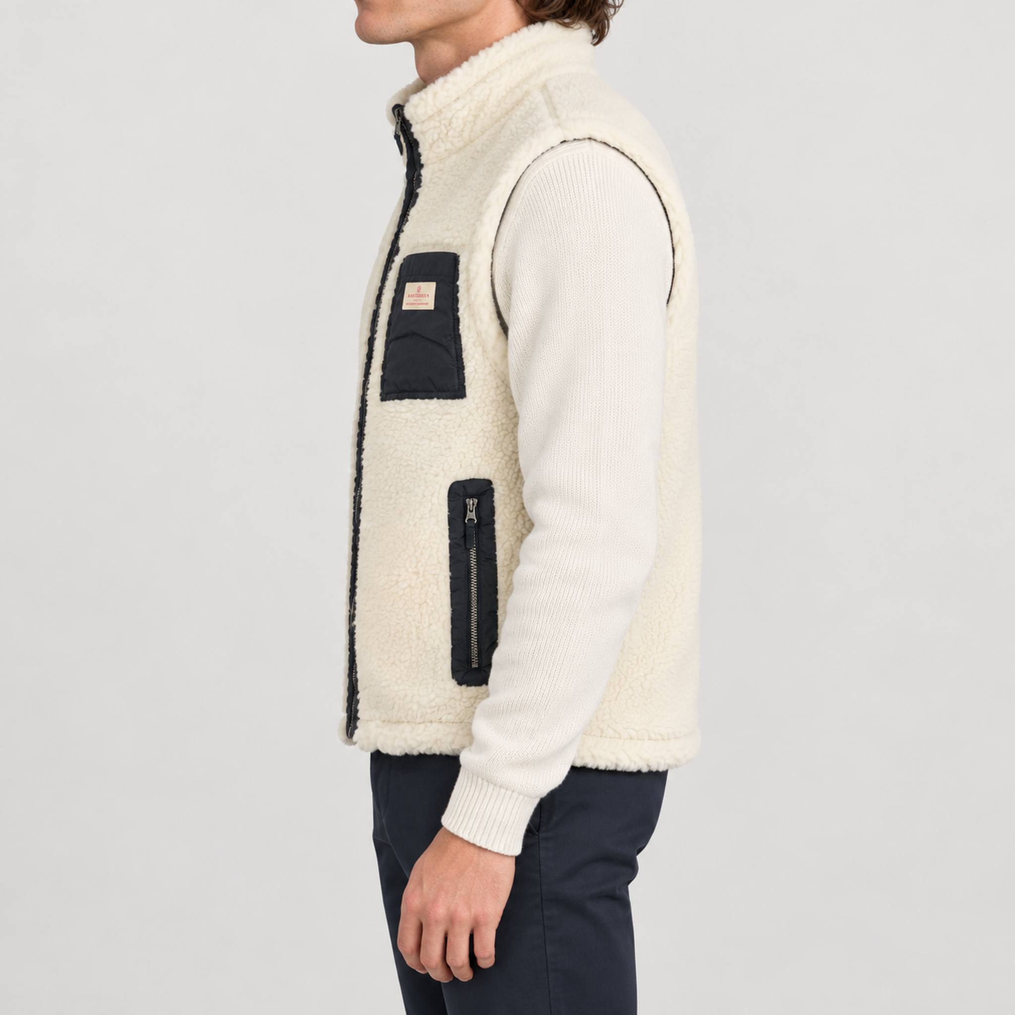 Amundsen Harvester Reverso Waxed Vest, side view on model, cream fleece side.