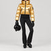 Goldbergh women's Bombardino Ski Jacket in Rich Gold – ski pose view. AI-generated from manufacturer imagery.