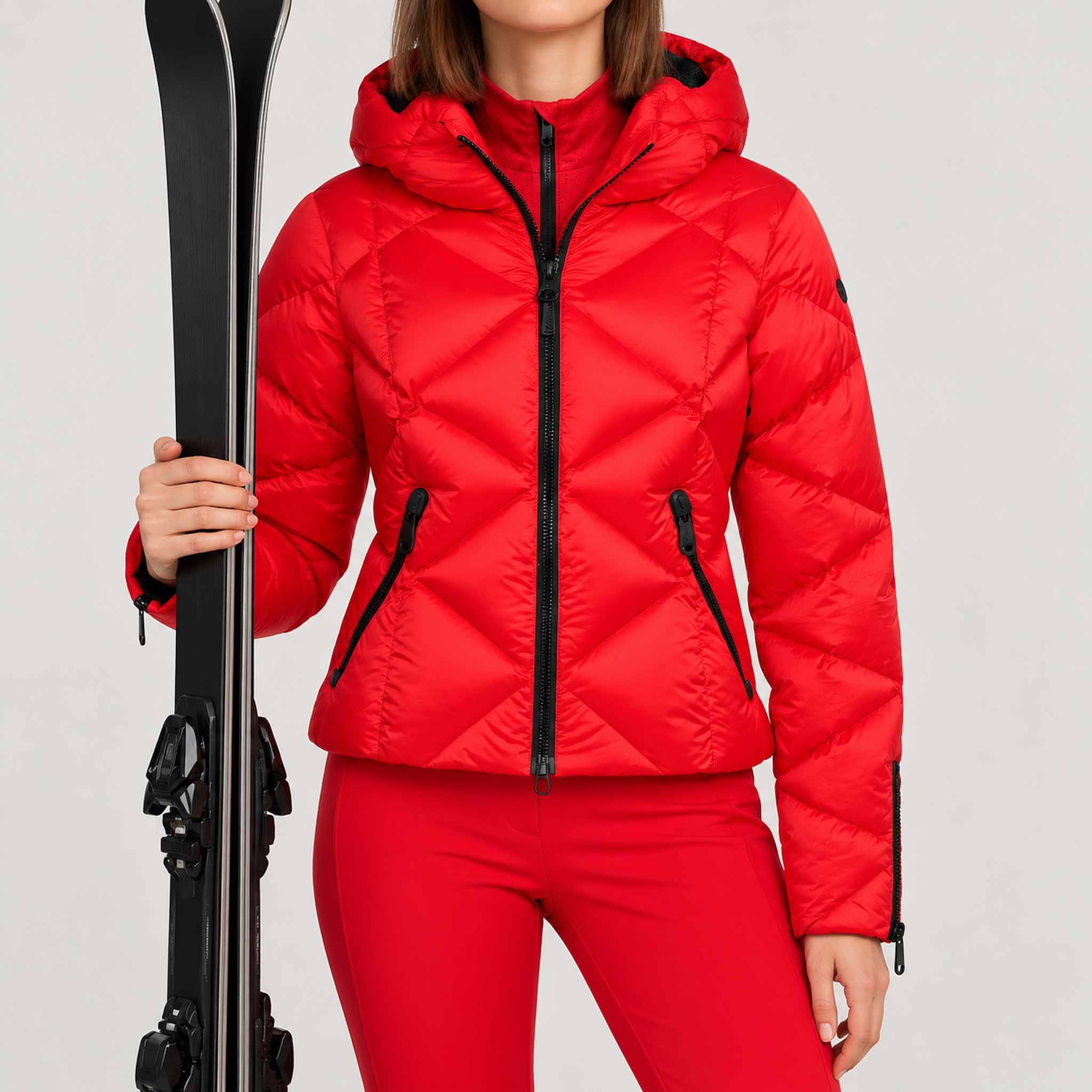 Goldbergh women's Harumi Ski Jacket in Flame Red – model ski pose standing with skis, plain cuffs without fur. AI-generated from manufacturer imagery.